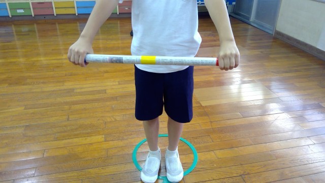 棒を両手で持っている