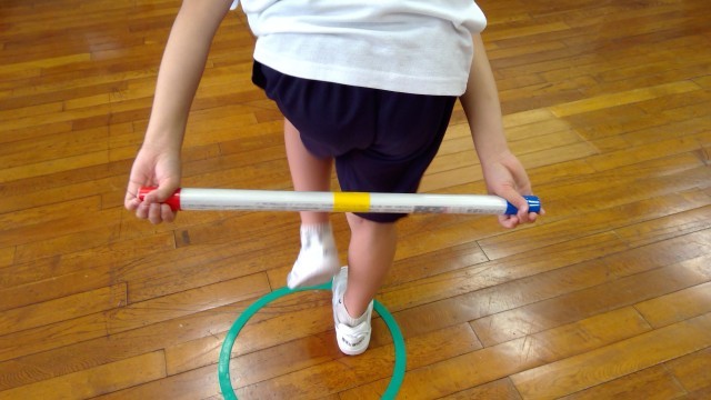 棒を後ろに回している