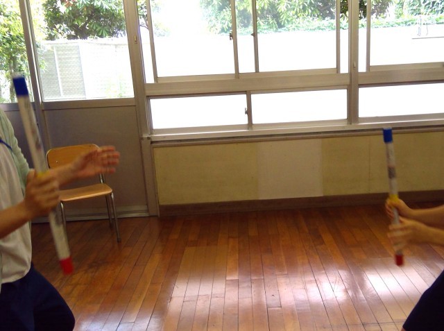 棒を二人で投げたりキャッチしたりしている