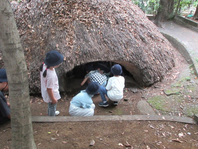 縄文時代の住居に入る体験をする様子
